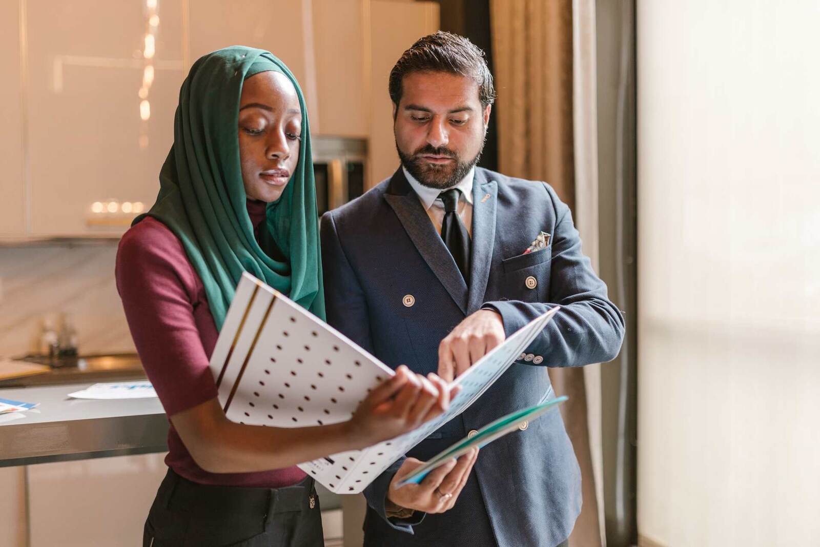 Two colleagues reviewing a printed document together in a bright office