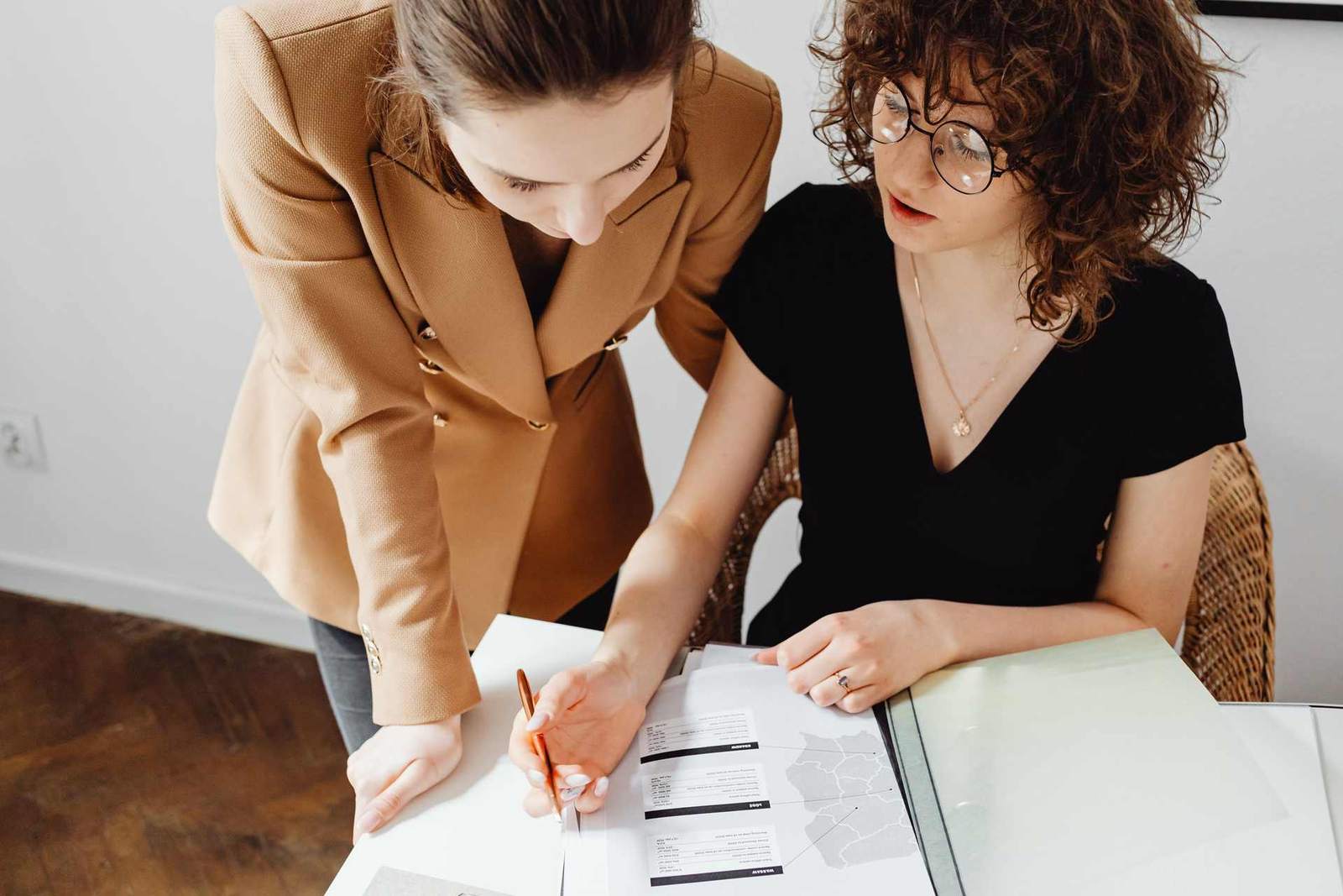 Two colleagues closely reviewing a printed data report together at a desk