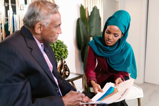 Senior regulatory consultant and colleague reviewing a chart-filled document together in a bright office