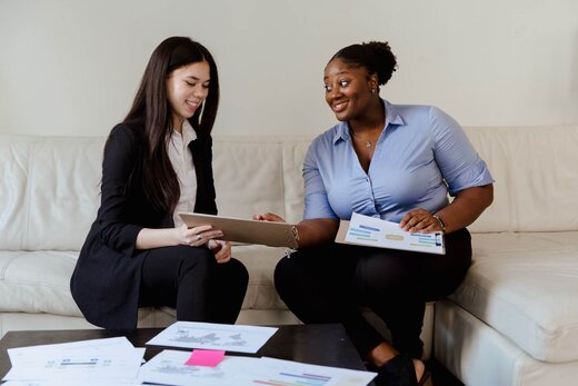 Two colleagues reviewing documents together in a bright modern office