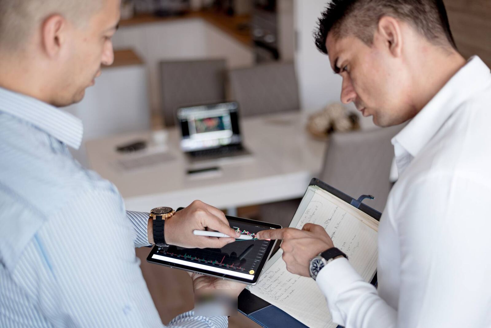 Two colleagues in a bright office review a device performance chart together on a tablet
