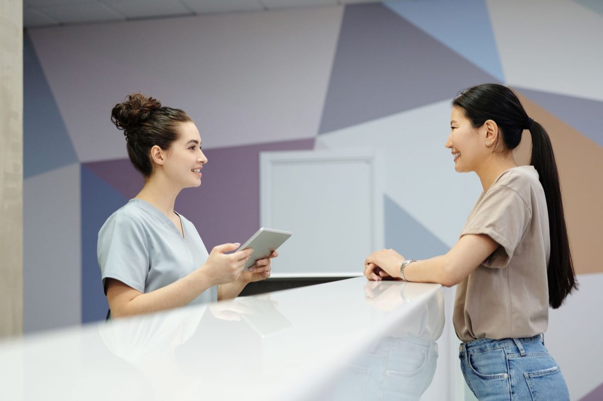 A visitor being received at a modern reception desk