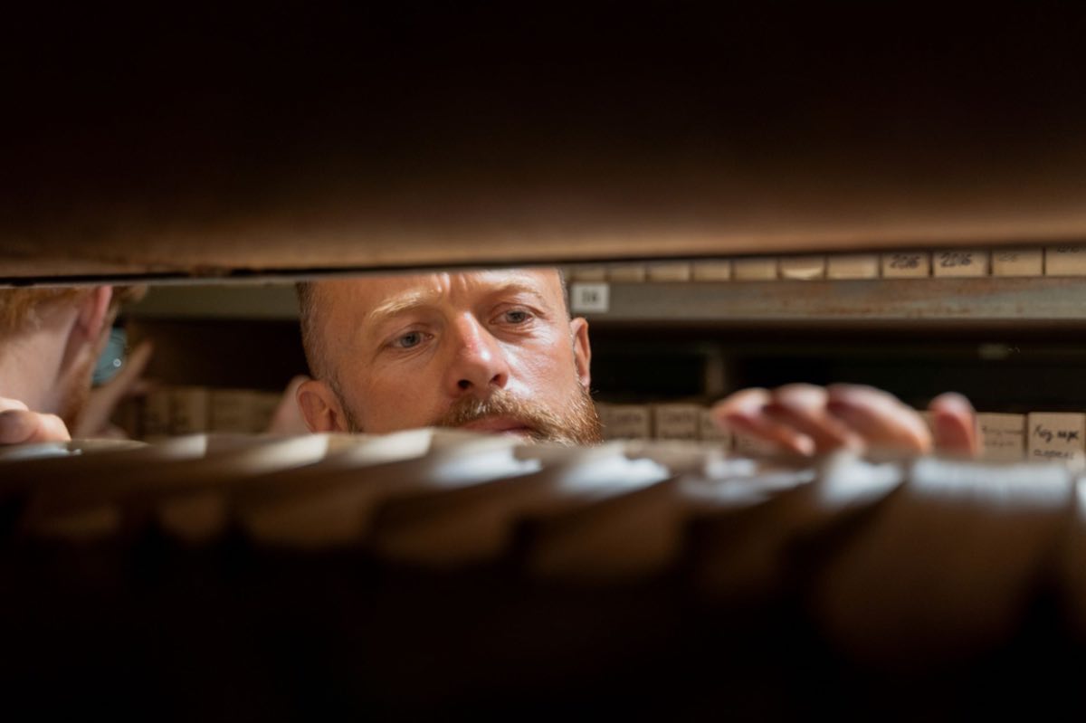 Quality specialist retrieving records from an archive room