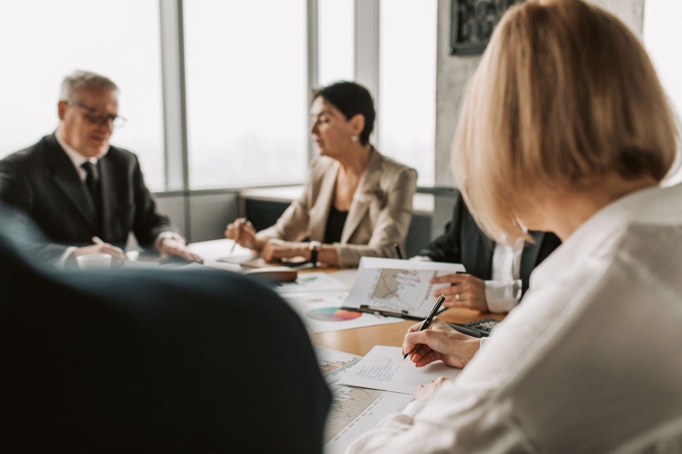M&A deal team negotiating terms over regulatory due diligence findings at a boardroom table