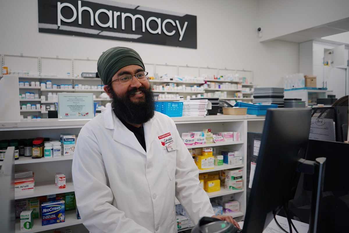A pharmacist working at the dispensing counter of a community pharmacy