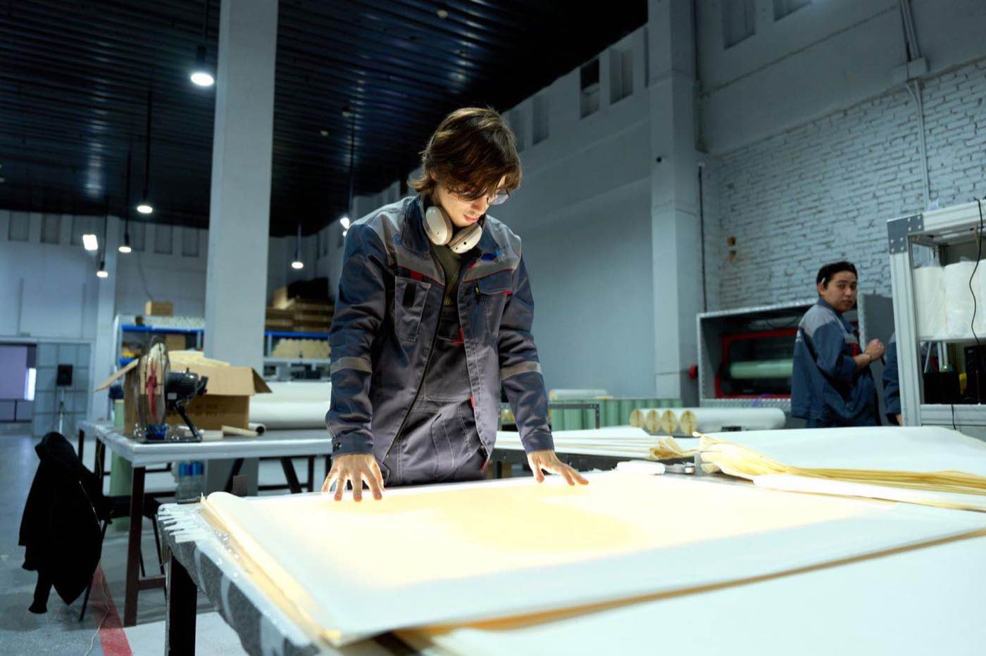 A quality auditor examining documents on a brightly lit factory floor