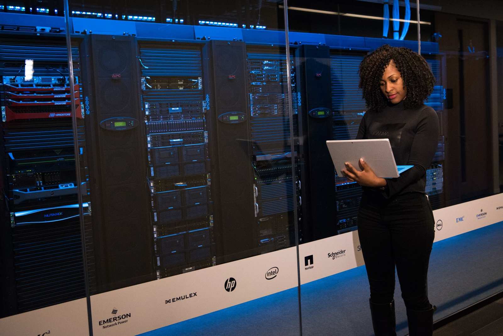 An engineer with a laptop monitoring rows of data servers