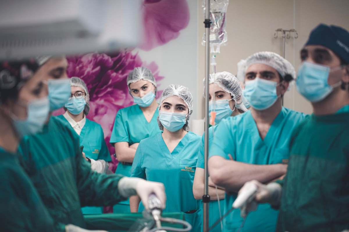 A medical team performing a laparoscopic procedure with tower monitors