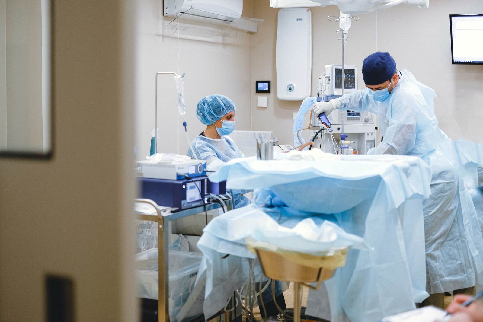 Surgeons and staff around advanced equipment in an operating room
