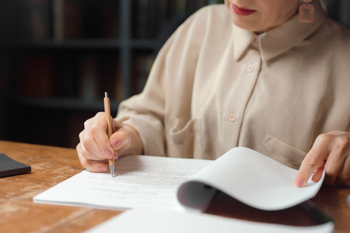 A writer working through a typed manuscript line by line with a pencil