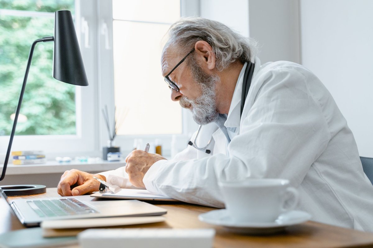 A senior medical writer working through a draft at his desk