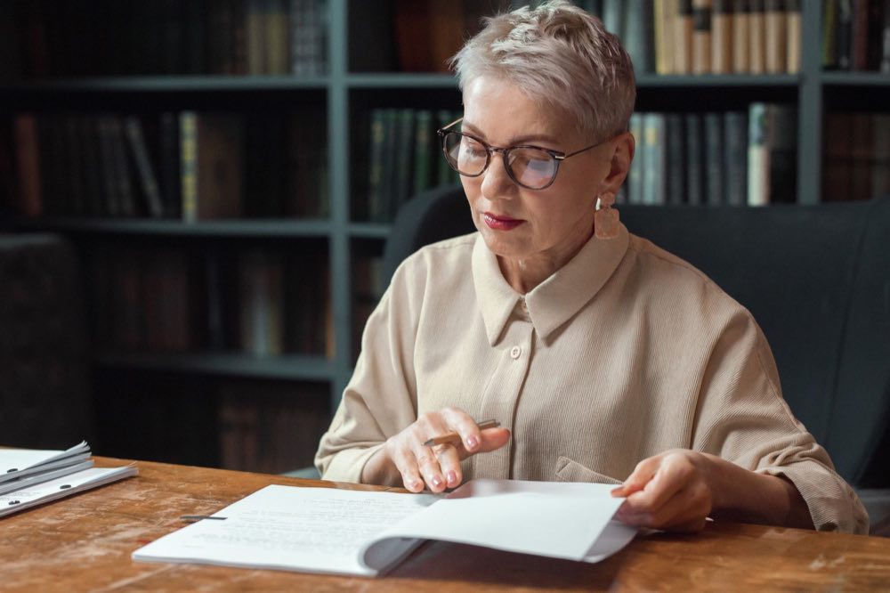 Senior regulatory medical writer reviewing a printed draft line by line
