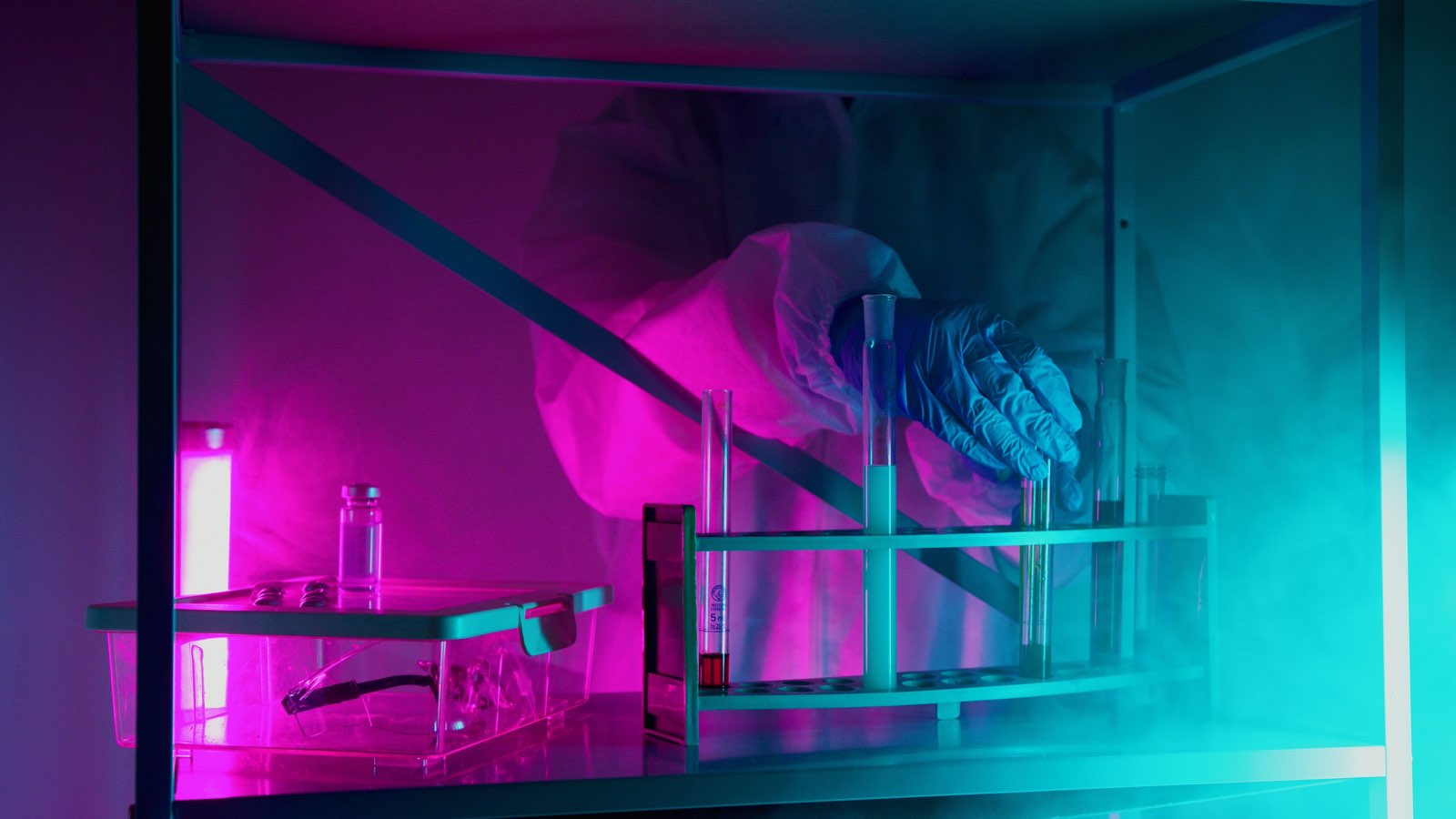 A scientist working with novel therapeutic samples under laboratory lighting