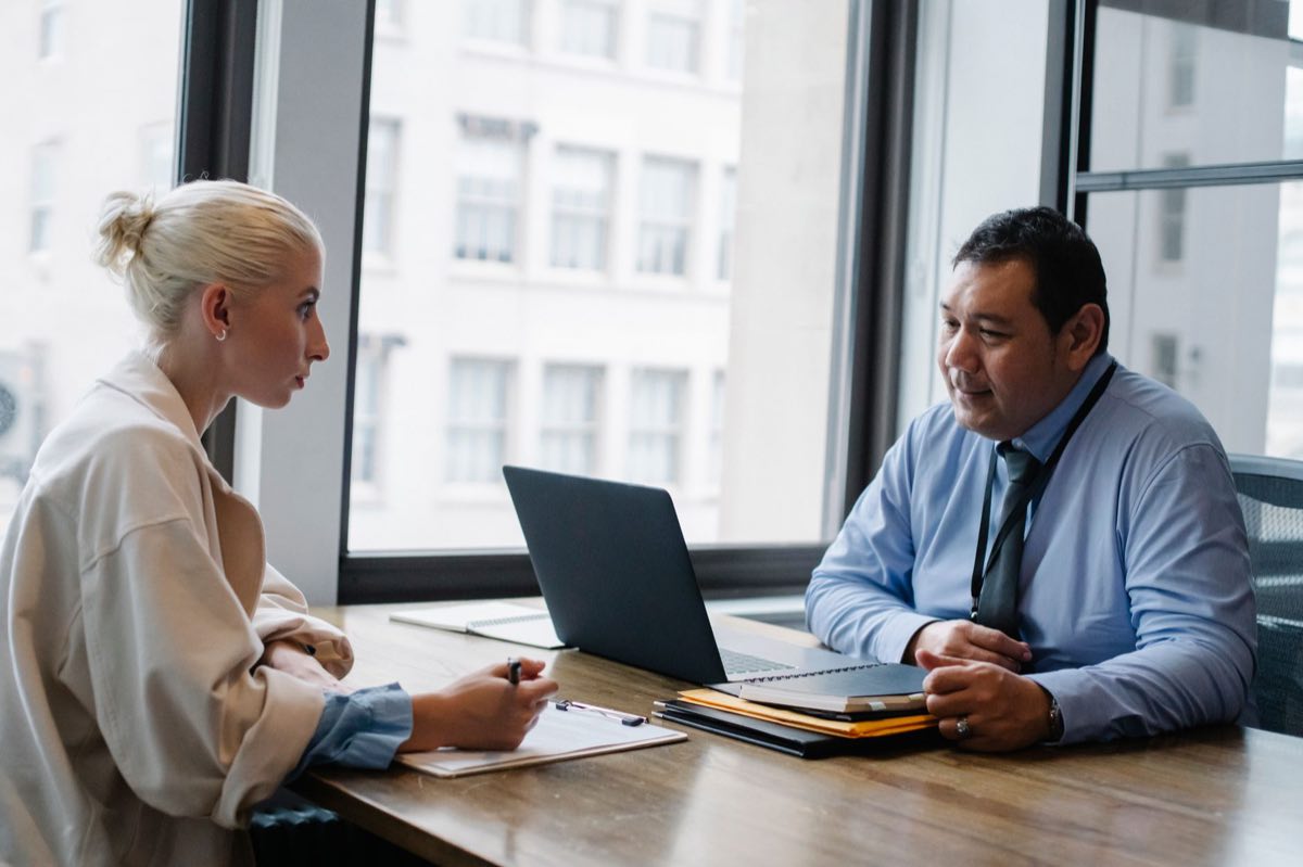 An interviewer questioning a professional who is completing a form