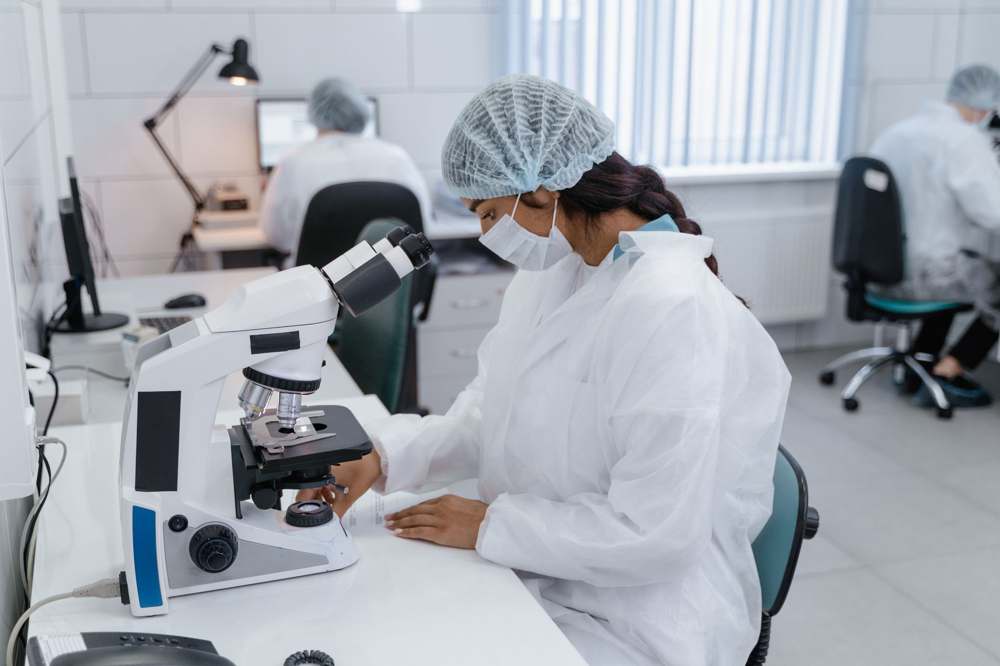 Researchers operating microscopes in a modern laboratory