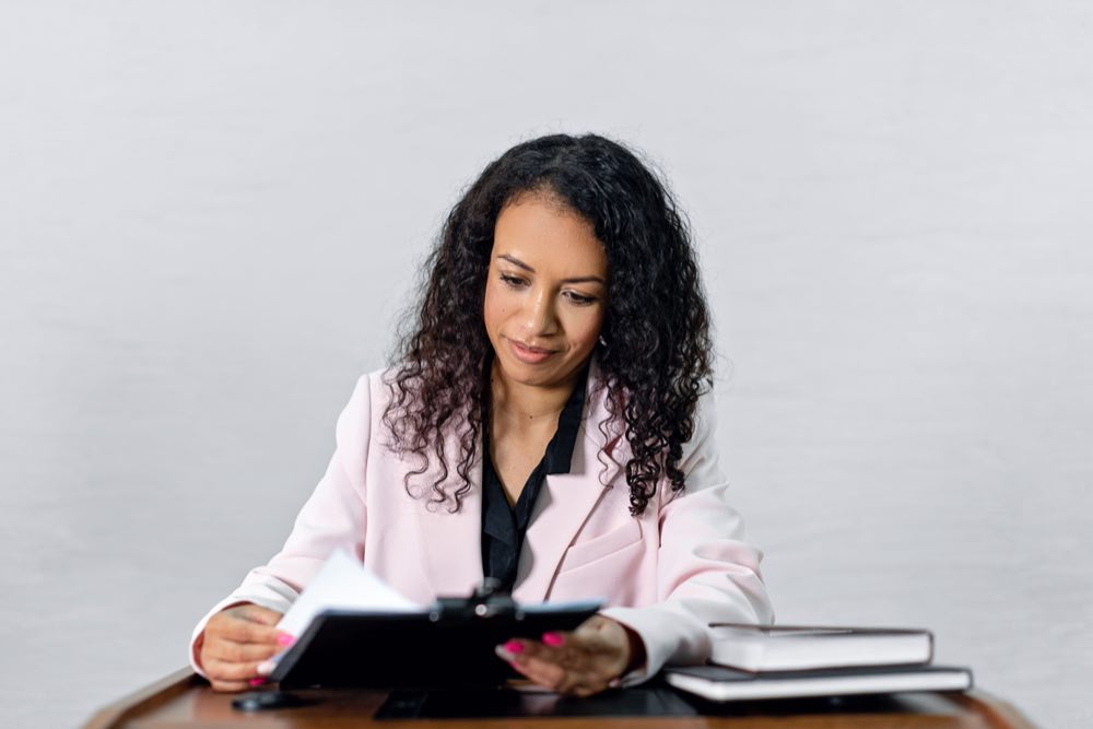 A professional reviewing documents intently at a desk