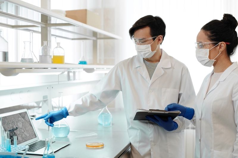 Two toxicologists interpreting study data at a laboratory workstation