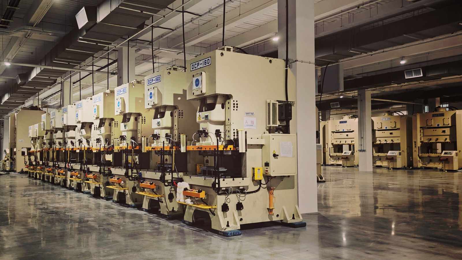 A row of industrial machines on a pharmaceutical factory floor