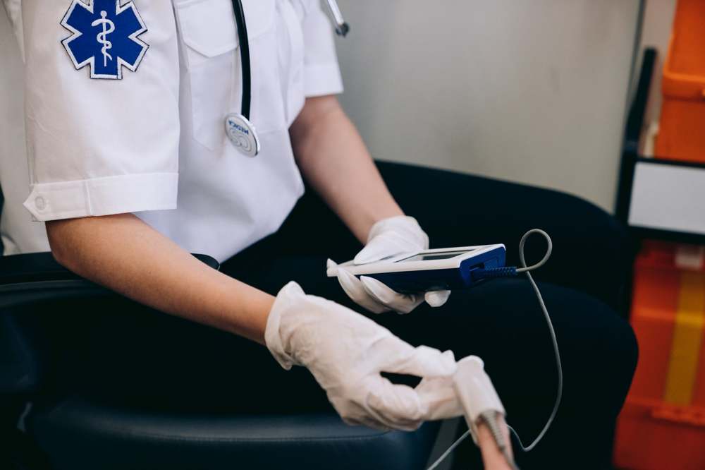 A clinician monitoring patient vitals with a handheld device