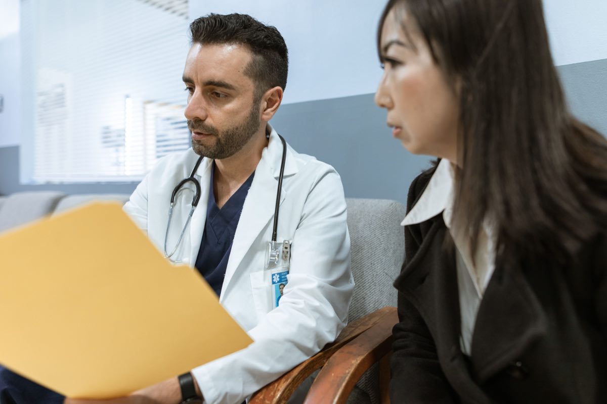 A physician reviewing records with a patient in clinic
