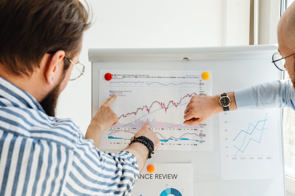 Colleagues working through statistical charts on a whiteboard