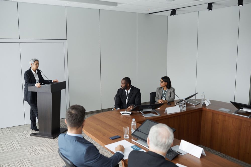 A senior team in formal discussion around a meeting table