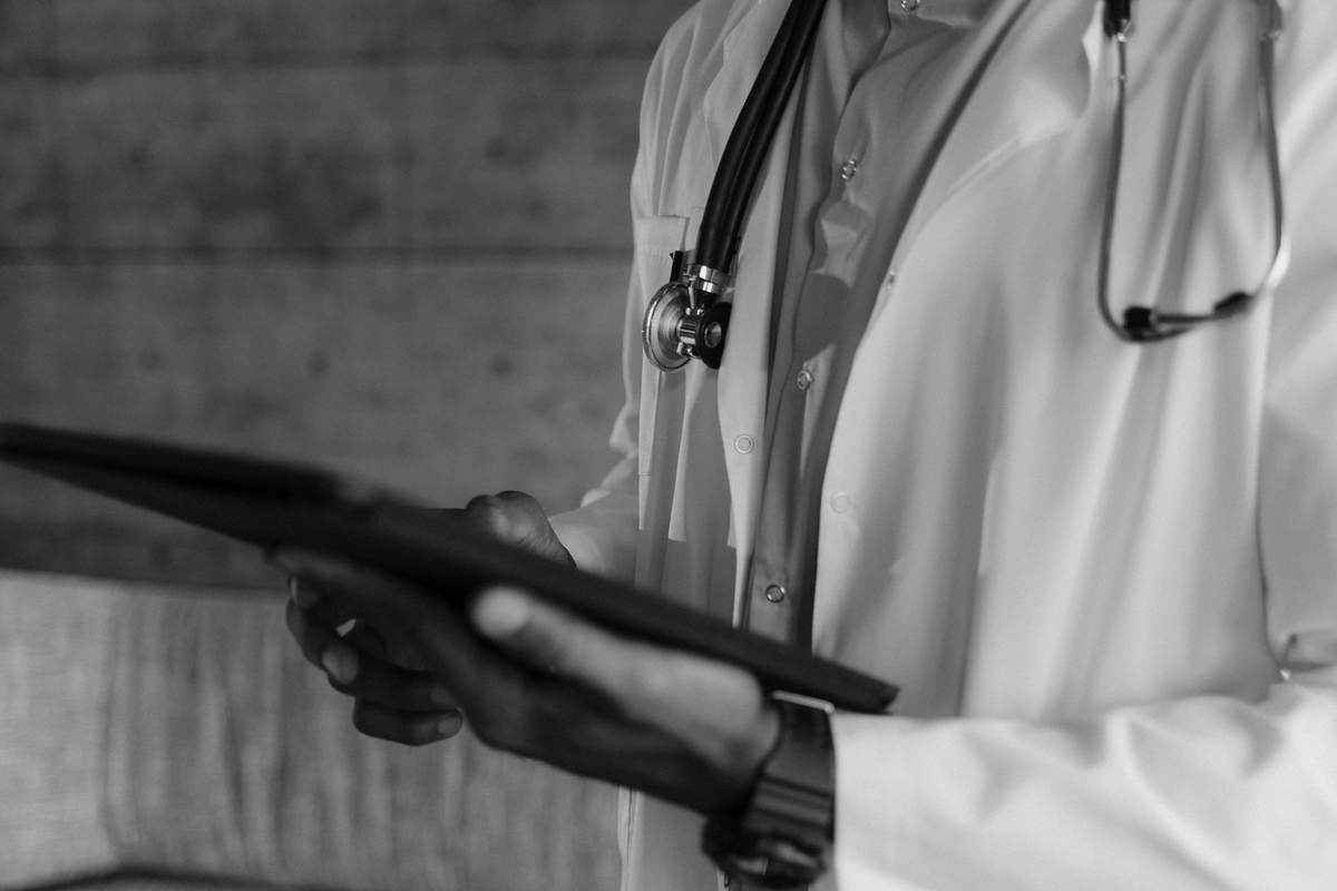 A medical practitioner holding a diagnostic device