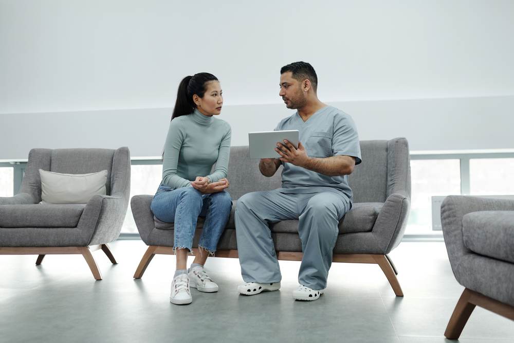 A healthcare provider consulting a patient with a tablet