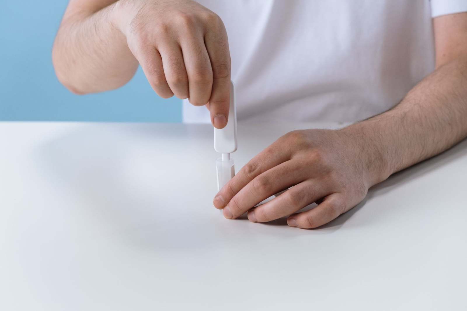 Hands preparing a rapid diagnostic test kit on a table