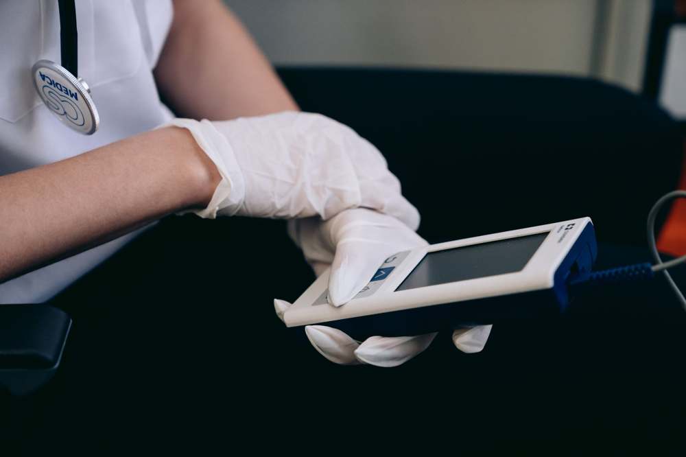 A healthcare worker using a handheld diagnostic device