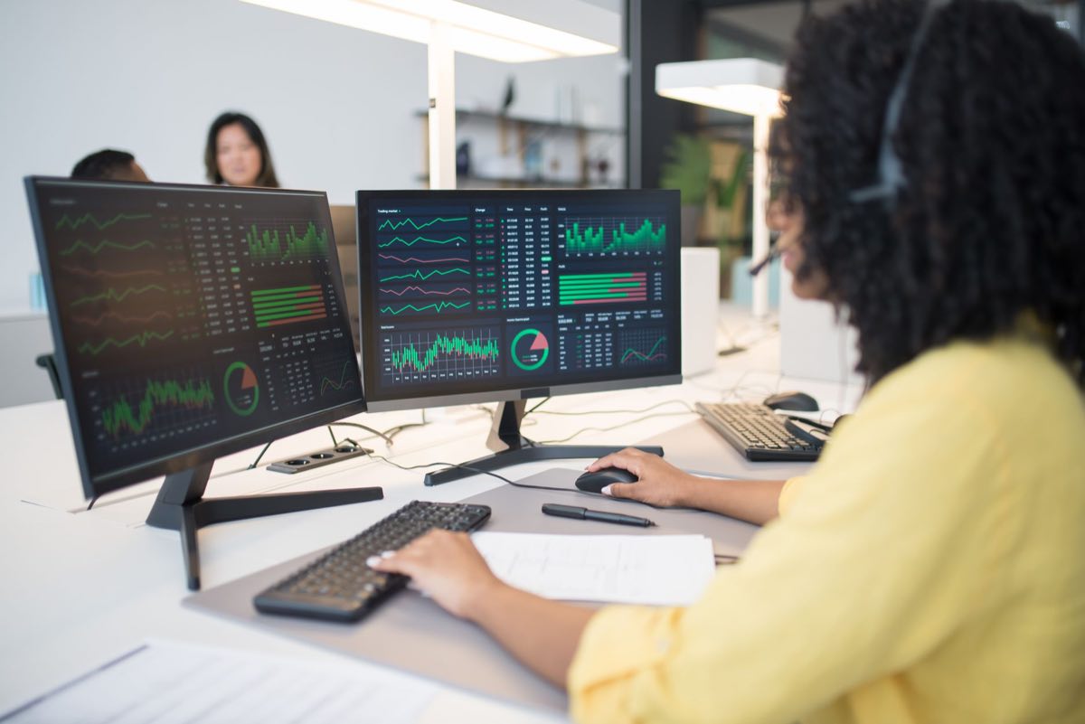 Analyst reviewing trend data across two monitors