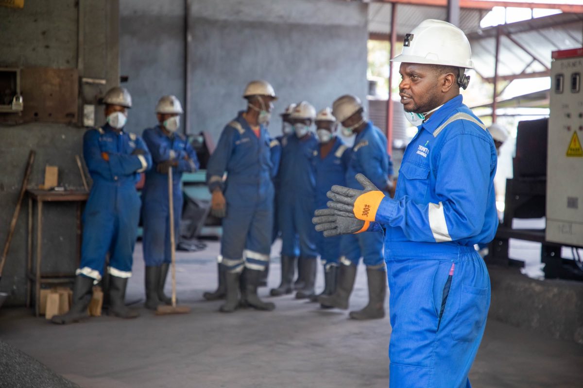 Factory workers in safety gear receiving training on the floor