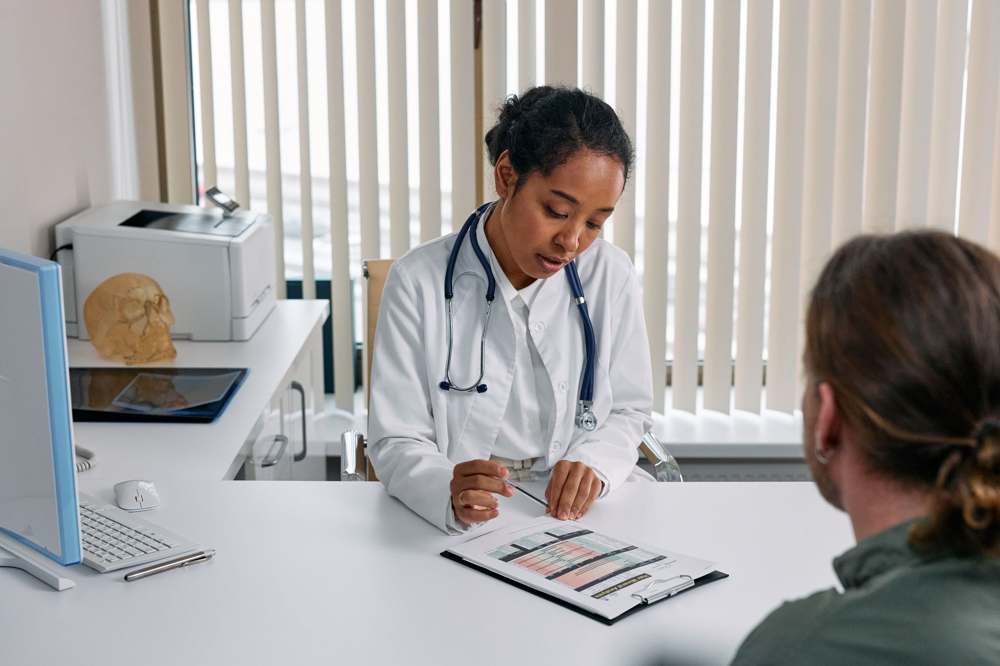 A clinician discussing treatment options with a patient in a consultation room