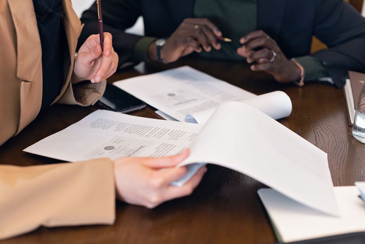 Senior regulatory professionals reviewing a submission dossier across a conference table