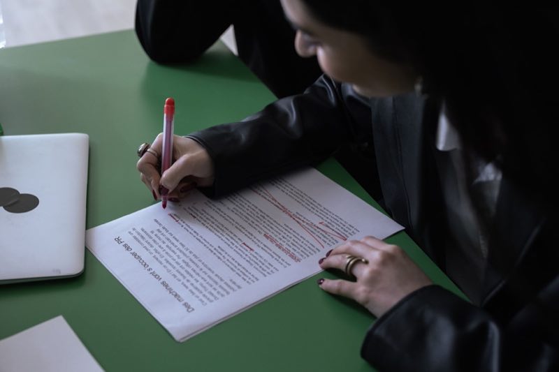 Regulatory analyst marking up a printed guidance document beside a laptop