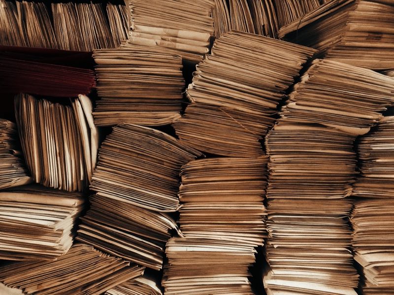 Stacks of legacy label records inherited across an acquired portfolio