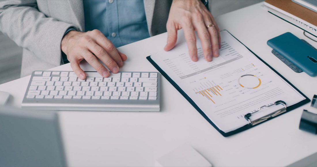 Hands processing regulatory documents at a workstation