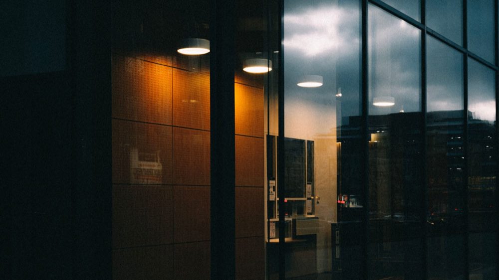 Office lit quietly at dusk, the regulatory operations machine running on schedule