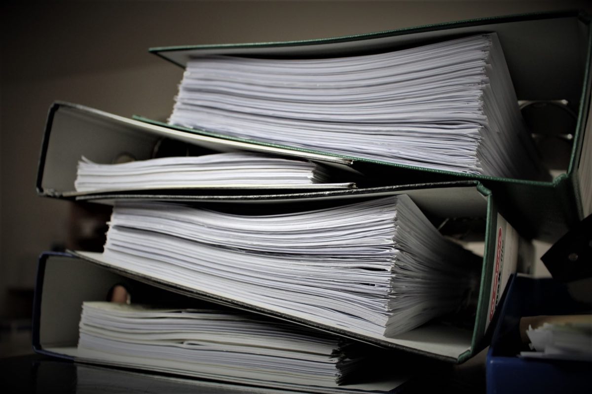 Stacked regulatory dossiers and binders ready for filing