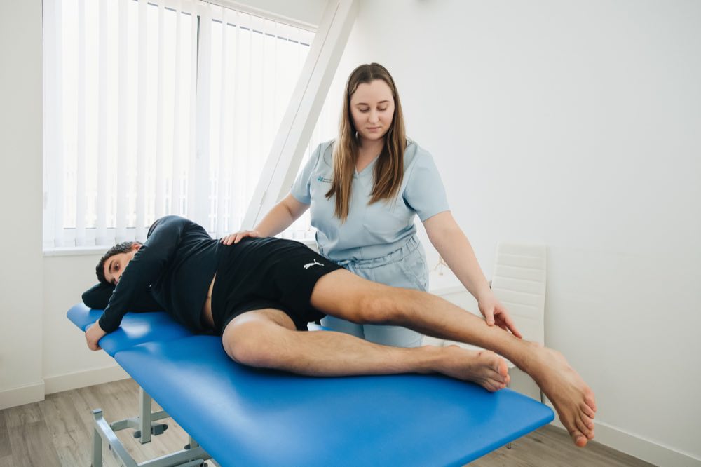 A physiotherapist assists a patient in a rehabilitation session at a Vilnius clinic