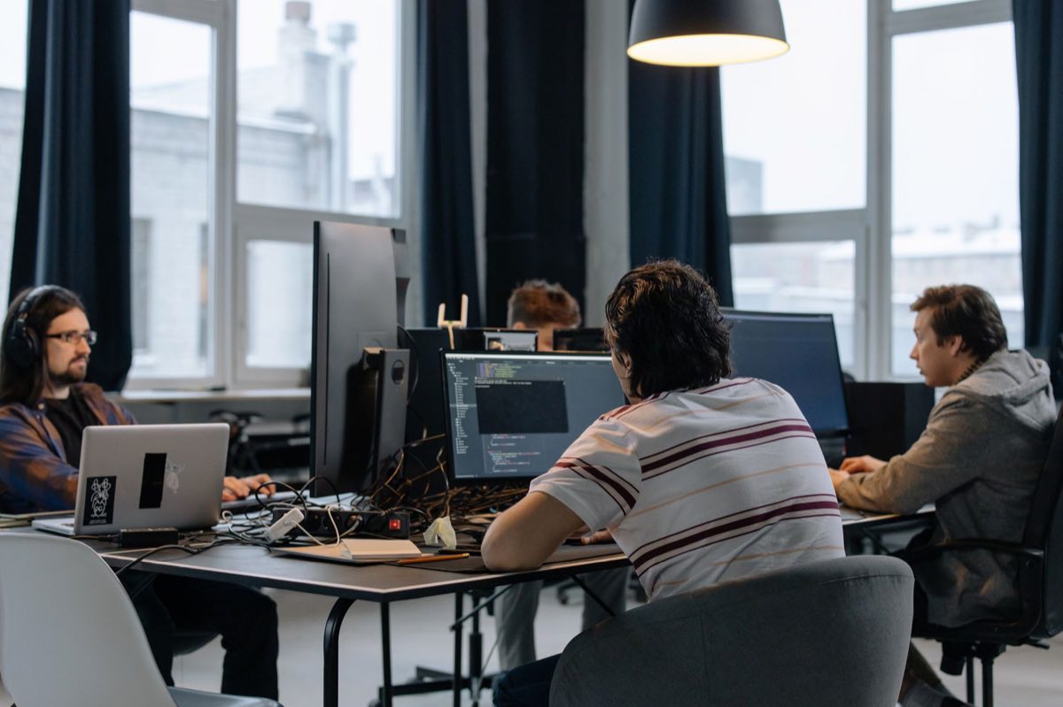 A team of software developers working together at computers in a modern office