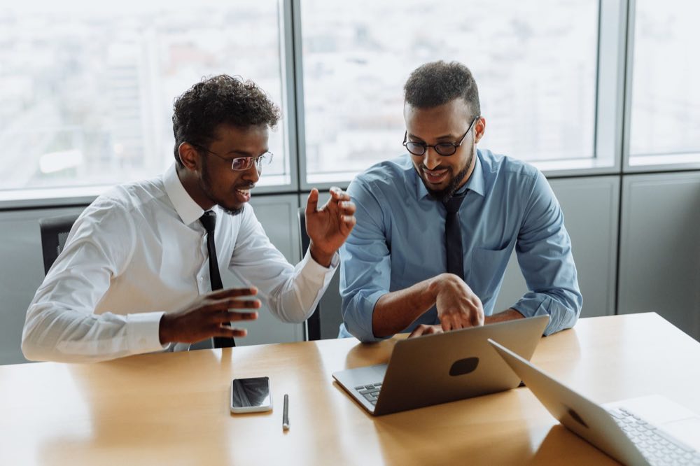 Business professionals collaborating over laptops in a modern office