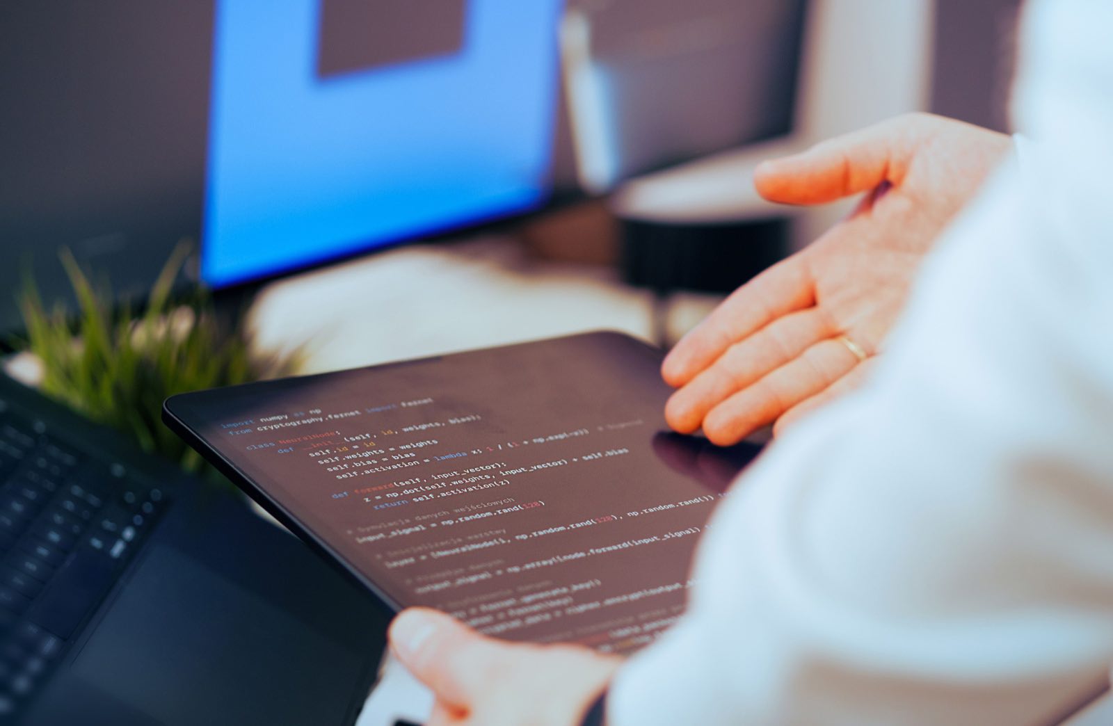 A software developer reviewing code on a tablet in a modern office