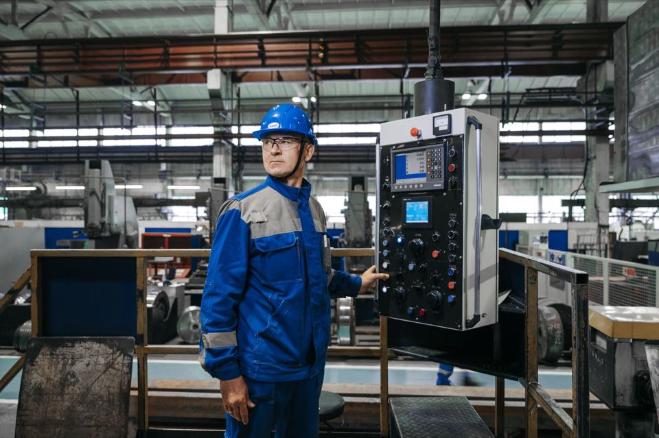 Engineer working at the control panel of production machinery
