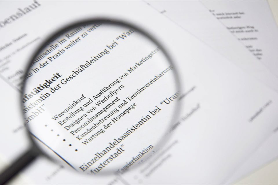 Magnifying glass resting on the fine print of a document