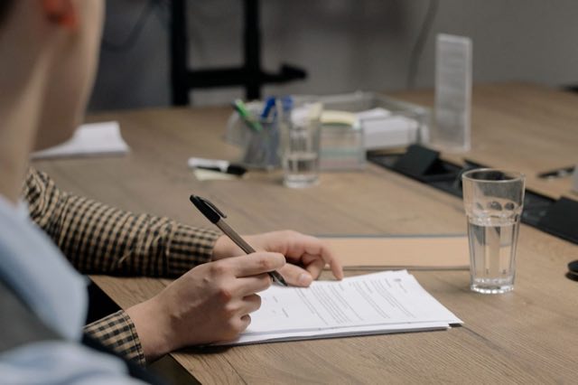 Writer working through a printed report with pen in hand