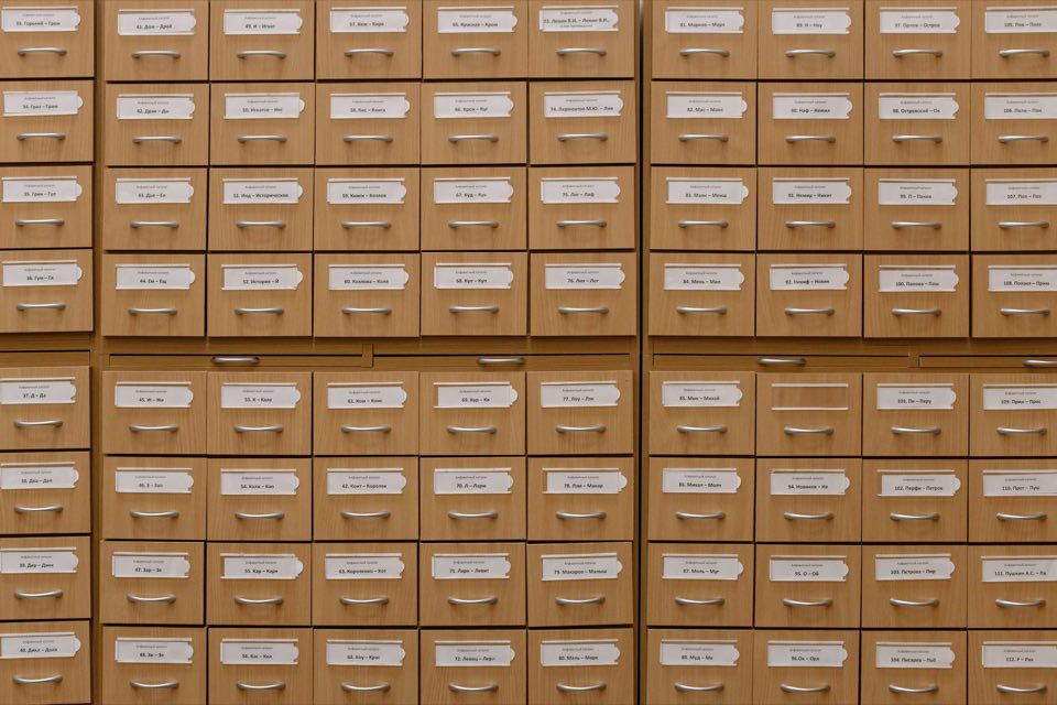 Wall of labeled catalog drawers in a records room