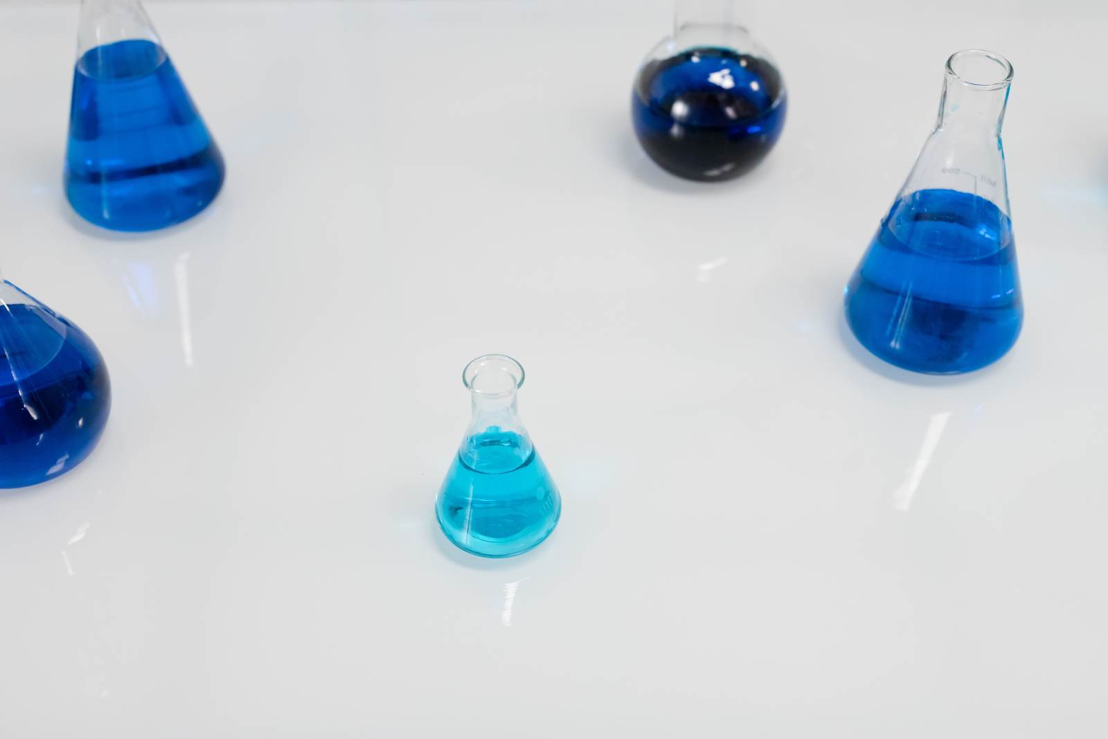 Glass flasks filled with blue liquid in a scientific setting