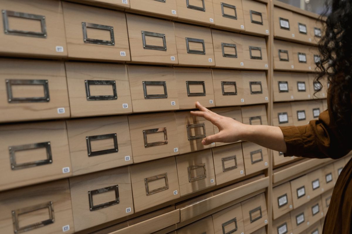 Archivist retrieving records from organized drawers