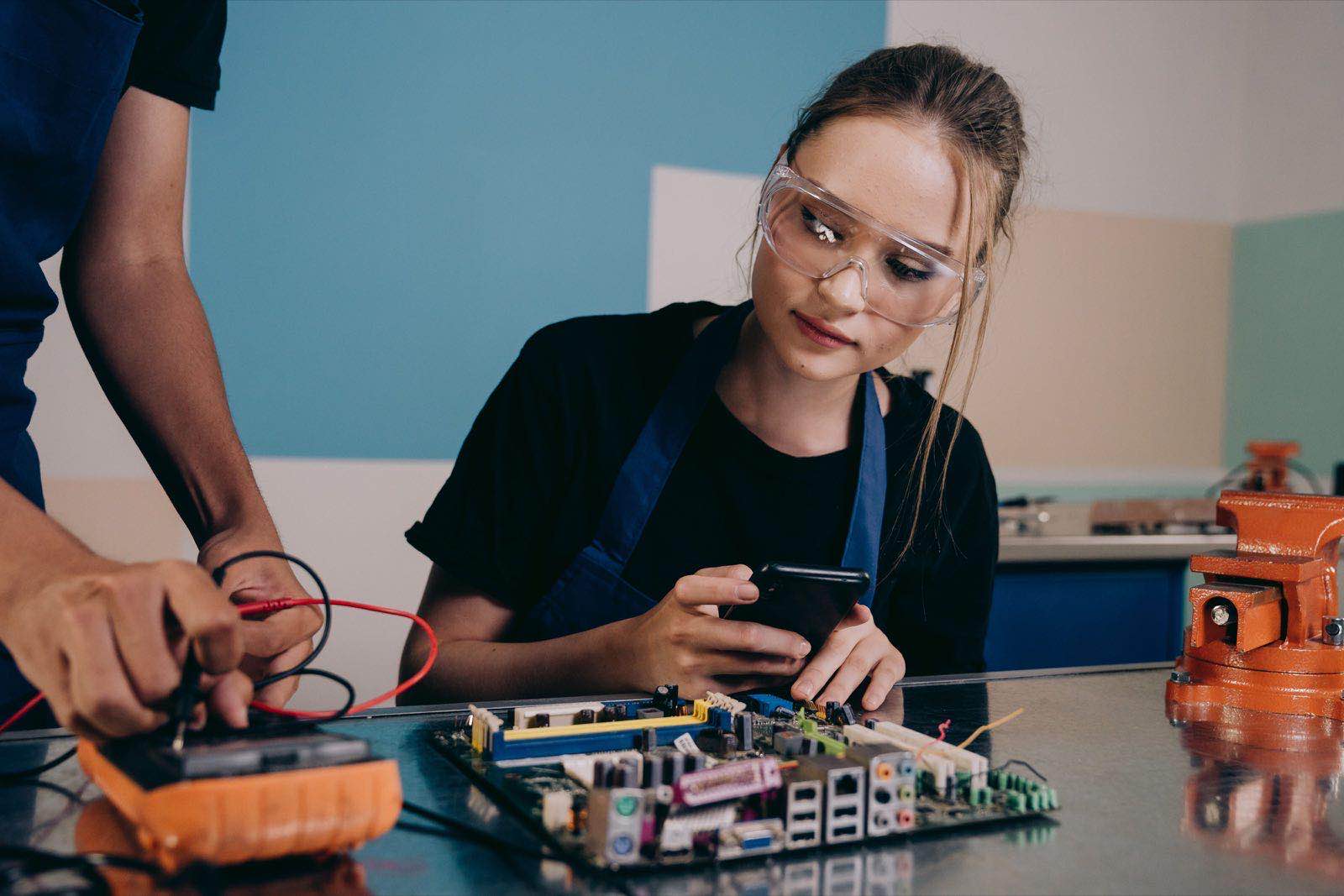 A technician examining a circuit board in an electronics workshop